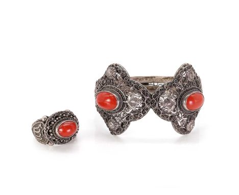 A silver coral bangle and ring,  with an oval coral cabochon to either side, both bezel set to a wide filigree mount, to a hi