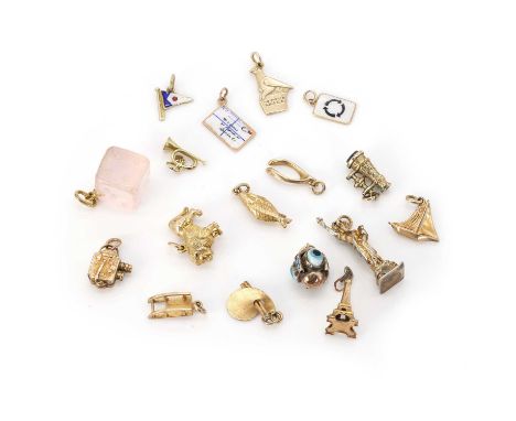 A collection of gold and gilt metal charms, comprising a gold fish charm, a gold rose quartz dice, both tested as approximate