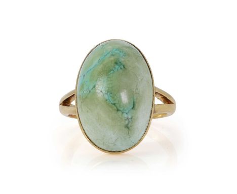 A single stone hardstone ring,  a large green hardstone cabochon, rub set to a plain collet, to bifurcated shoulders and a 'D