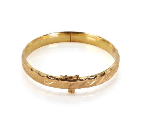 A gold hinged bangle, with a rolling 'S' pattern, in a satin finish, 16mm wide with a flower screw clasp and safety catch, te