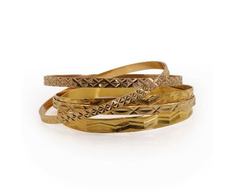 Five gold bangles, comprising an Egyptian gold round bangle, a flat section bangle with an embossed zigzag pattern, 7mm wide,