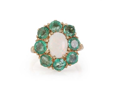 A 9ct gold opal and emerald cluster ring,  with an oval cabochon opal claw set to the centre, encircled by a surround of roun