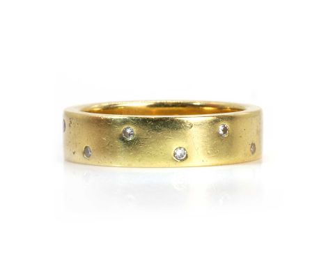 An 18ct gold diamond wedding ring,  with round brilliant cut diamonds rub set and spaced alternating between each side, to a 