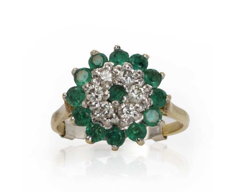 A gold emerald and diamond target cluster ring,  with round cut emeralds and round brilliant cut diamonds, claw set in white 