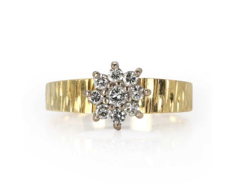 An 18ct gold diamond daisy cluster ring,  with a daisy cluster of brilliant cut diamonds, all claw set and mounted to a taper