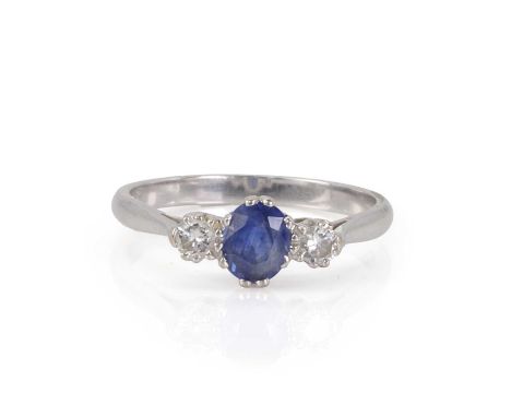 An 18ct white gold sapphire and diamond ring,  set with an oval mixed cut sapphire flanked by a round brilliant diamond each 