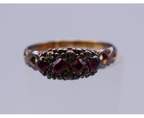 An 18 ct gold diamond and garnet ring. Ring size J/K. 1.6 grammes total weight. 