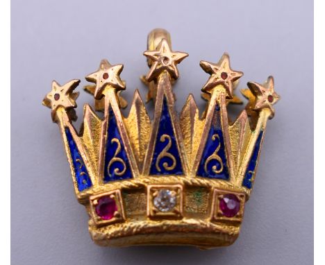 An unmarked gold, enamel, diamond and ruby set crown form pendant.  2 cm x 2.25 cm. 6 grammes total weight.