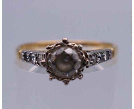 An 18 ct gold ring set with diamond chip shoulders. Ring size P. 2.4 grammes total weight.