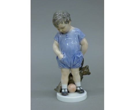 A Royal Copenhagen model of a boy with a teddy bear. 18 cm high.