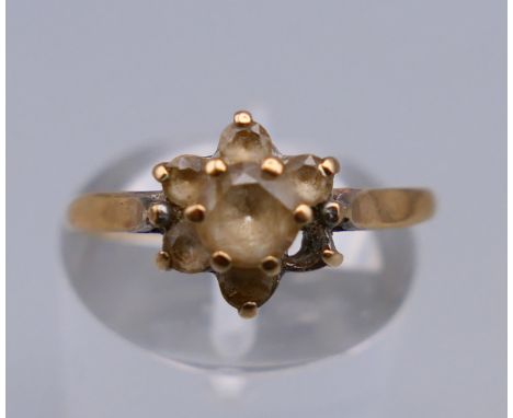 A 9 ct gold flowerhead ring. Ring size O. 1.5 grammes total weight.