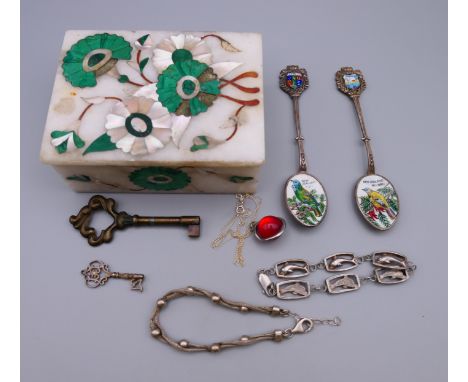 A marble box, containing two silver bracelets, a necklace, key and two enamel spoons.  Spoons 11.5 cm long.