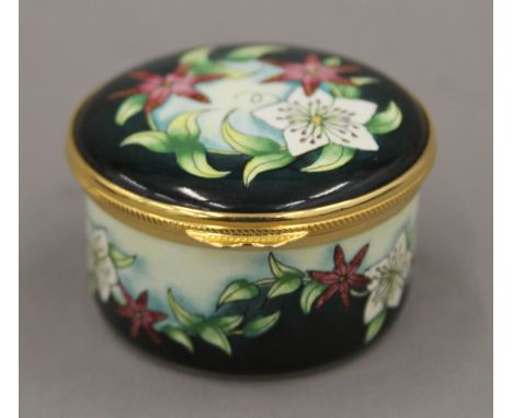 A boxed Moorcroft enamel Christmas Rose box. 5.5 cm diameter.