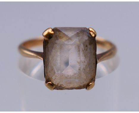 A 9 ct gold emerald cut ring. Ring size L. 2 grammes total weight.