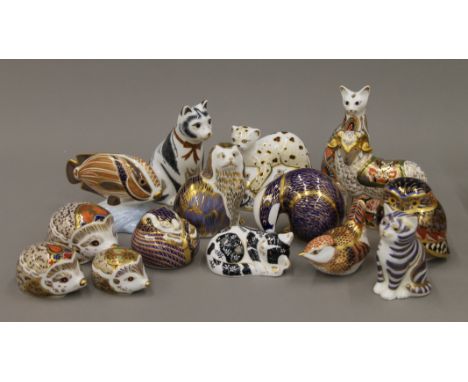 A collection of Royal Crown Derby paperweights including cats, bird, owl, hedgehogs, ram, fish, etc.