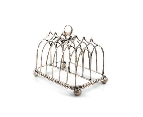 A George III silver seven-bar toast rack, by Cradock and Reid, London 1812, arched wire-work bars, central ring handle, on a 