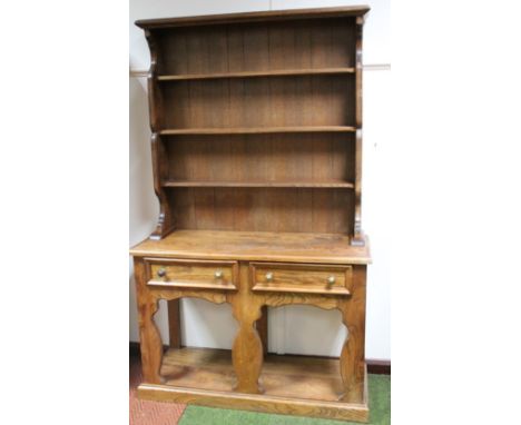 A 20thC light elm dresser, the upper section with a fixed cornice, raised above Delft racks and two frieze drawers, with hour