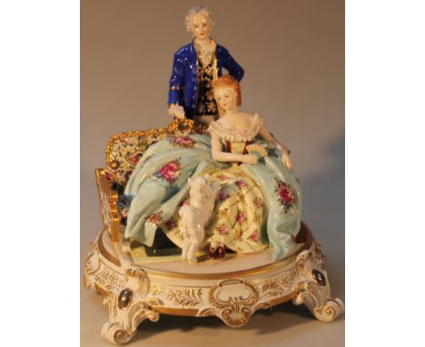 An R K Dresden figure group, of a gentleman standing before a lady and puppy, polychrome decorated with floral highlights on 