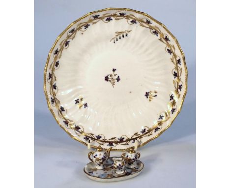 An early 19thC Derby plate, of dished shaped circular form with a gilt outline and floral banding, sparsely decorated with fl