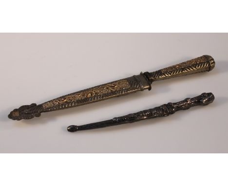 An early 20thC gilt metal Argentinian dagger, with a plain blade and elaborate floral highlighted scabbard, with floral handl