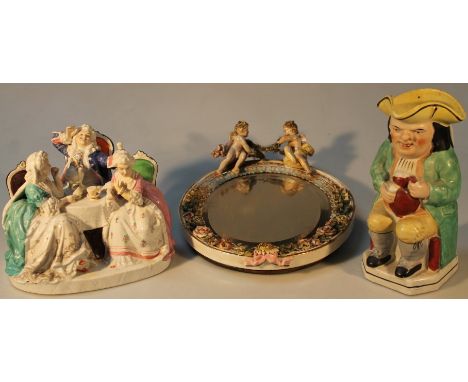 A late 19thC Staffordshire Toby jug, of typical form in seated position with green jacket, waistcoat and yellow breeches on a