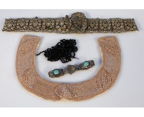 A 20thC filigere style metal nurses belt, of elaborate pierced scroll and floral form, together with a studded synthetic pear