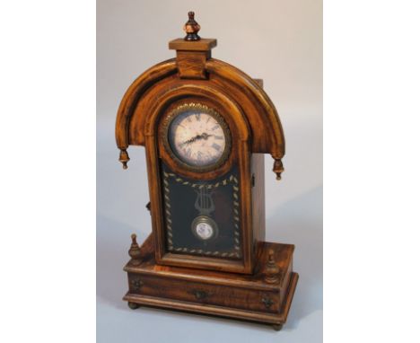 An early 20thC stained beech clock case, the arched circular case set with urn finial above a circular Roman numeric dial fro