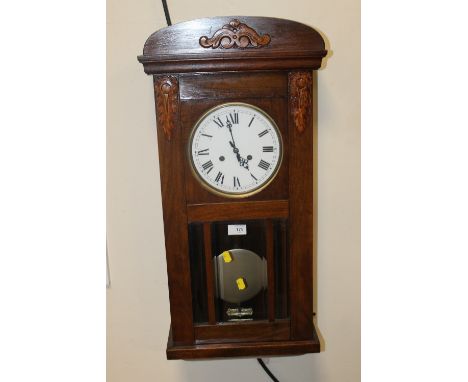 A CARVED WALL HANGING CLOCK