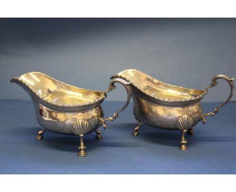 A pair of silver sauce boats, by William Comyns & Son, London 1938, on three shell decorated hoof feet, 462.5g.   Condition R