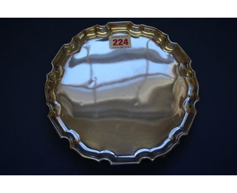 A silver waiter, by W B, Sheffield 1943, having pie crust rim on three stylised hoof supports, 20cm, 250g.