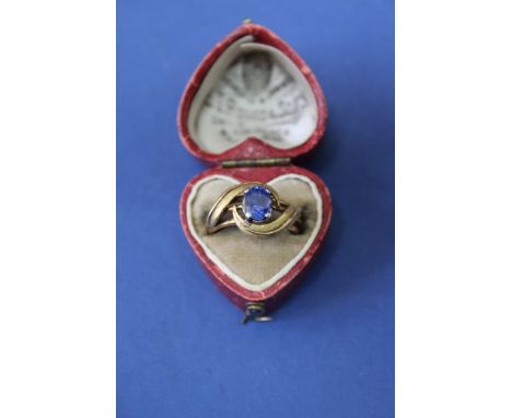 An unmarked yellow metal ring set central oval sapphire, in vintage heart shaped box.  Condition Report: Sapphire edges rubbe