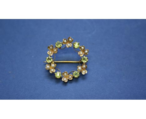 A 15ct gold bar brooch set blue topaz and seed pearls; together with a 9ct circular brooch set peridot and seed pearl; and an