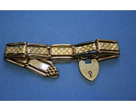 A Victorian unmarked gold gate bracelet, having woven central decoration attached to a 15ct gold clasp. 20g.