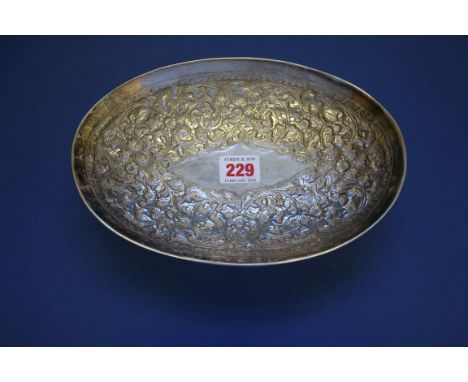 A foreign metal oval dish, having repousse floral decoration, stamped Garman silver, 23cm.