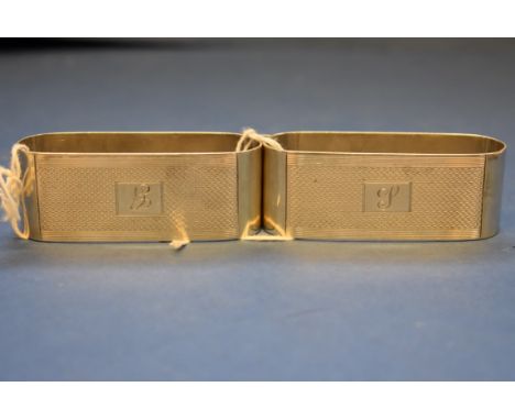 A pair of engine turned silver elliptical napkin rings, by John Rose, Birmingham 1934, 7cm, 69g. Condition Report: Engraved i