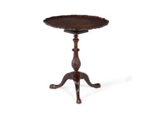 A mahogany tilt top occasional table, circa 1760 and later, with piecrust edge and birdcage action above the lappet carved ba