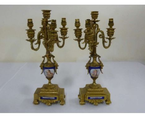 Pair of gilt metal and porcelain five light candelabra on raised squares bases