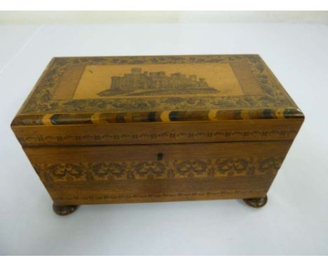 A Tunbridge ware tea caddy, rectangular form on four bun feet, the hinged cover decorated with a castle