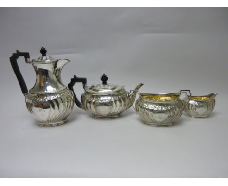 An Edward VII silver four piece Tea Service of gadrooned oval form with floral frieze and presentation inscription and initia