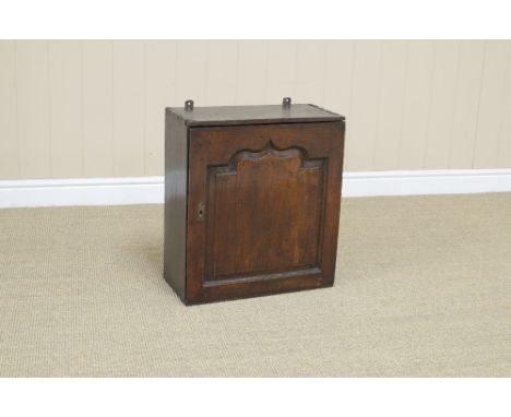 An 18th Century oak Spice Cupboard with single fielded panelled door enclosing nine small drawers above a shelf, 20in H x 18i