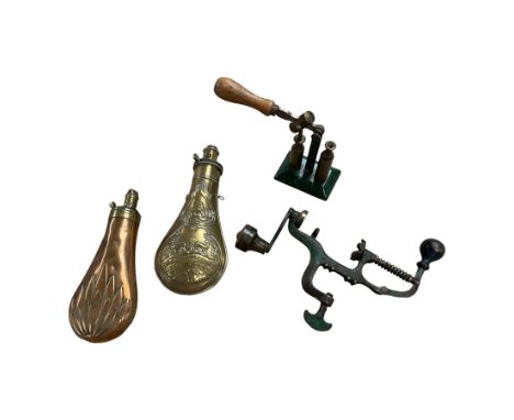 Two 19th century powder flasks, the brass example decorated in relief with deers, together with two cartridge reloading tools