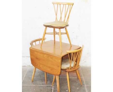 An Ercol light elm and beech drop leaf table with two twist back chairs and another.