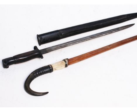 A bayonet and a horn handled walking stick