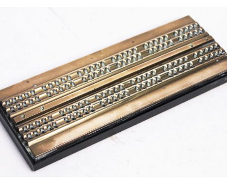 A brass and black glass cribbage board. L23.5cm