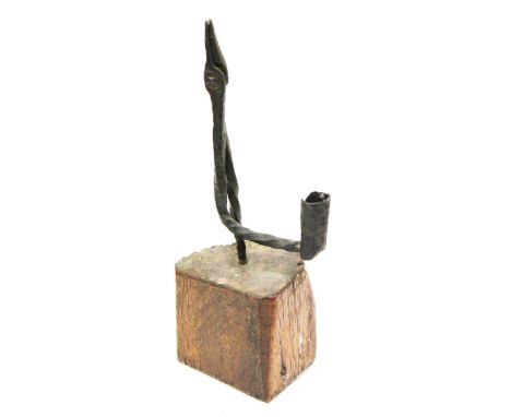 A wrought iron rush light on a wooden base. H25cm