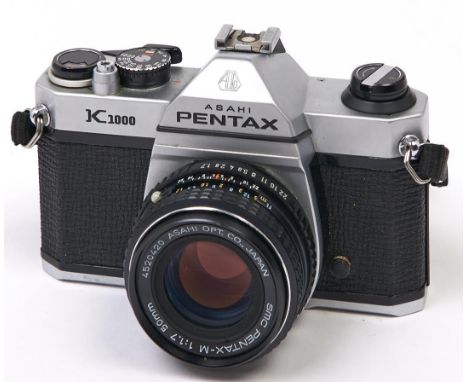 A Pentax K1000 SLR camera, with SMC Pentax-M 50mm F2 lens  In apparently working order, good condition, lens could benefit fr