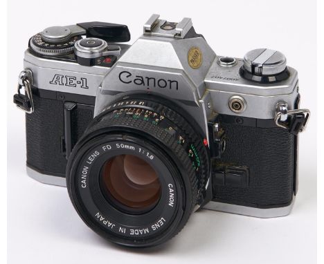 A Canon AE-1 SLR 35mm camera, with Canon FD 50mm F1.8 lens  In apparently working order, wear consistent with age, lens dusty