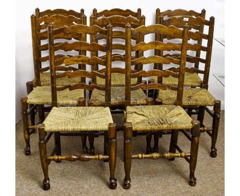 Eight stained ash ladder back chairs, early 20th c, rush seated, seat heights 45cm and circa  Handling wear on top rails, bru