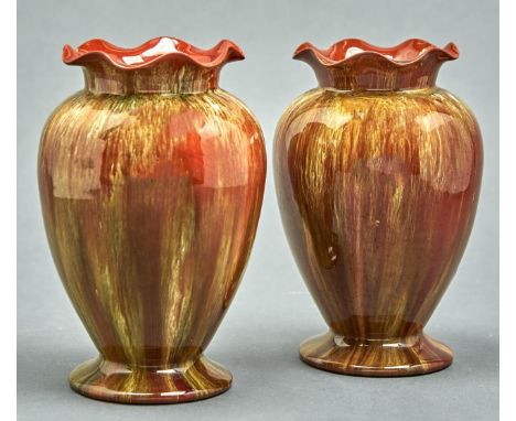 A pair of Linthorpe art pottery vases, c1885, with frilled neck and spreading foot, covered in a streaked green glaze, 17.5cm