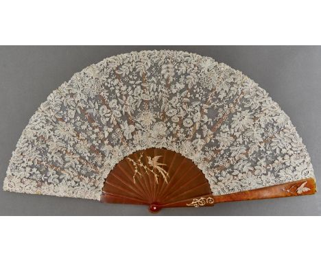 A Belle Epoque&nbsp;jewelled blonde tortoiseshell fan, c1914,&nbsp;with diamond set naturalistic gold mounts of a bird on a b